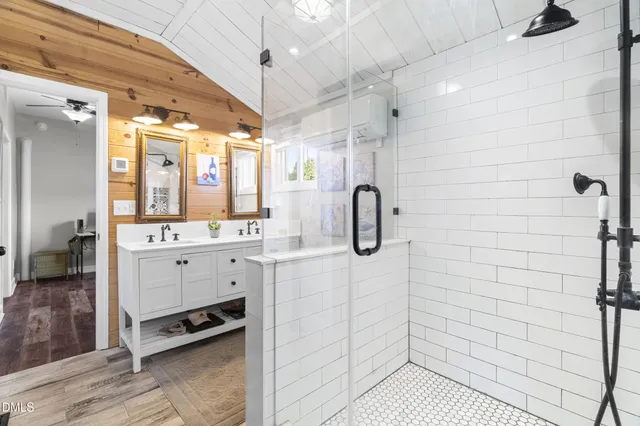 a bathroom with a shower a sink a mirror and shower