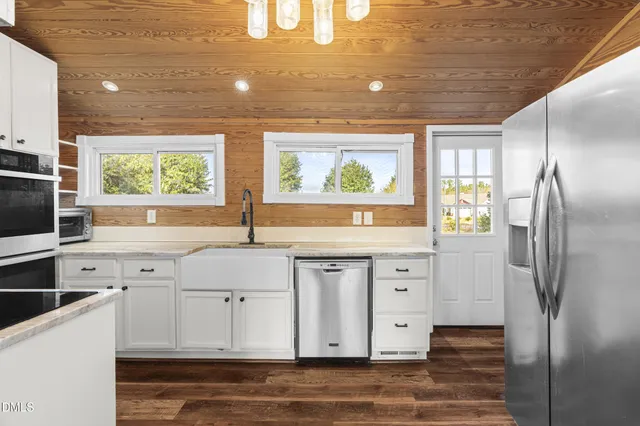 a kitchen with stainless steel appliances a refrigerator sink and cabinets