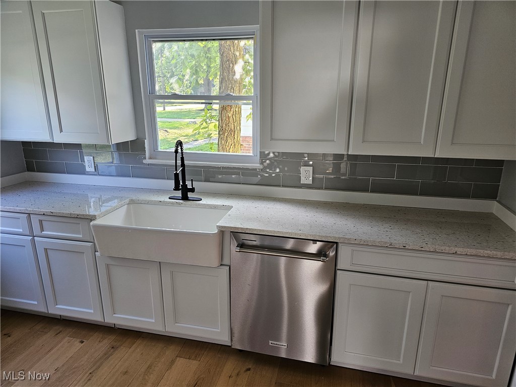 3999 Lancaster Road South Euclid, OH 44121 - Photo 3 of 17 Kitchen featuring tasteful backsplash, light hardwood / wood-style flooring, dishwasher, light stone countertops, and white cabinetry