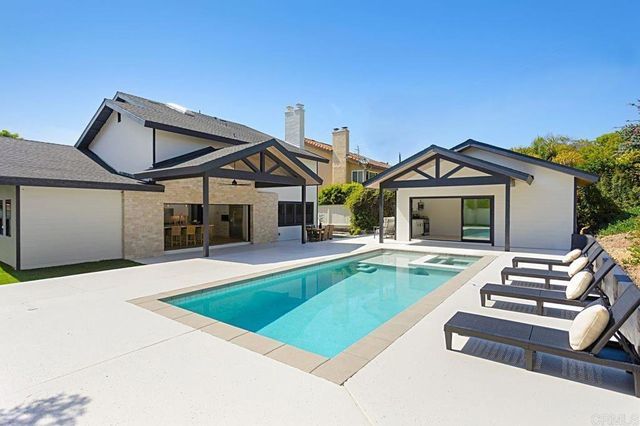 a front view of a house with swimming pool having outdoor seating