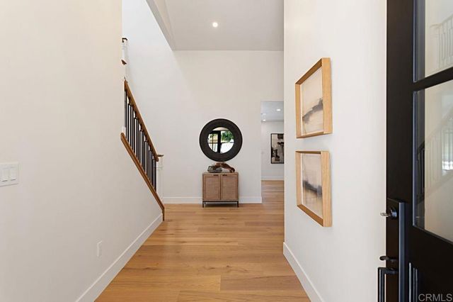 a hallway with stairs and a wooden floor