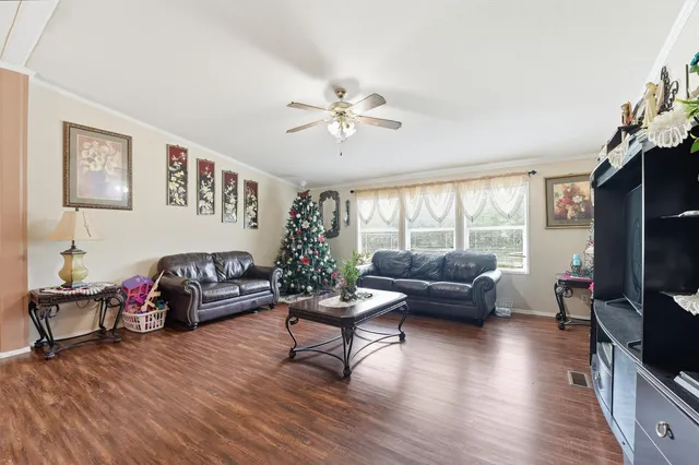 a living room with furniture flat screen tv and wooden floor