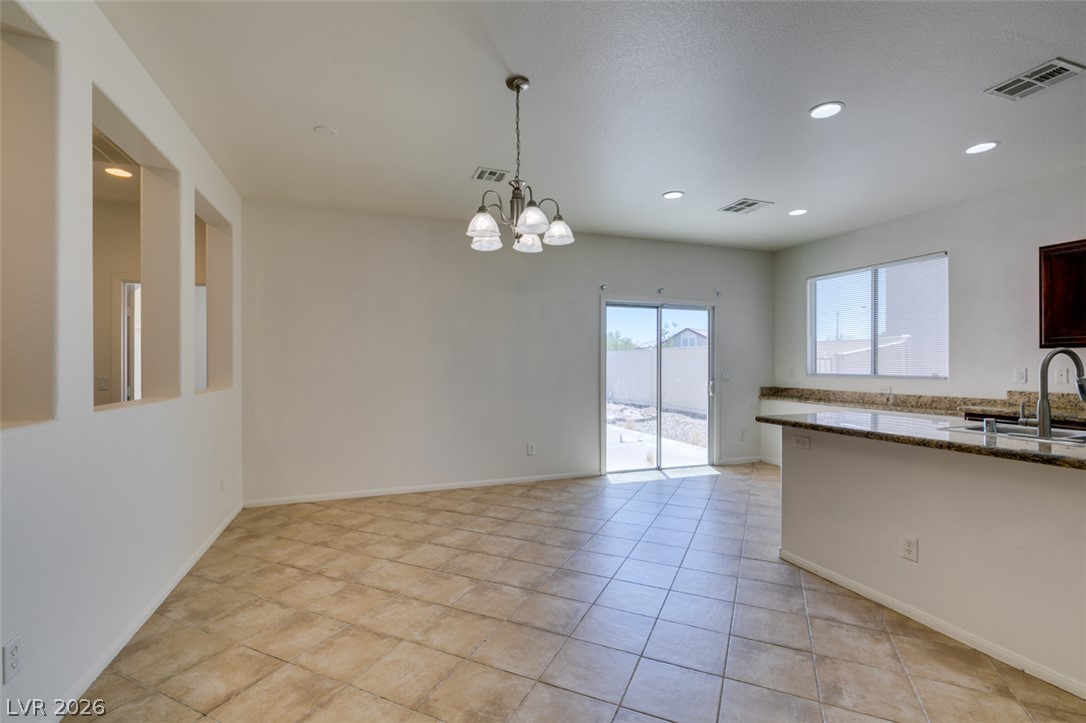 5150 Riverside Run Court North Las Vegas, NV 89081 - Photo 19 of 50 A spacious dining area with tile flooring and a view of the private outdoor space.