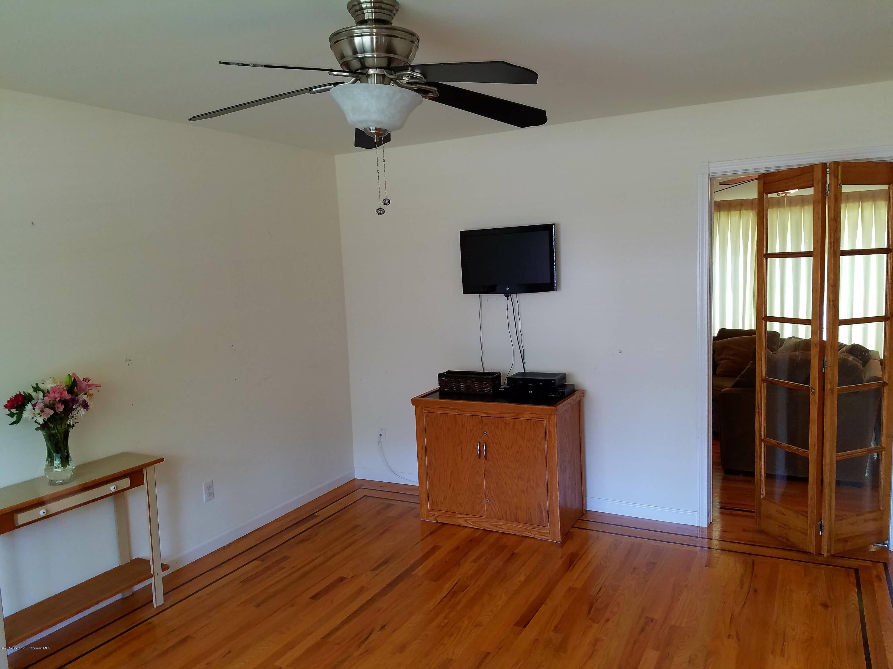 126 Robin Road Neptune Township, NJ 07753 - Photo 11 of 24 a view of room with wooden floor and ceiling fan