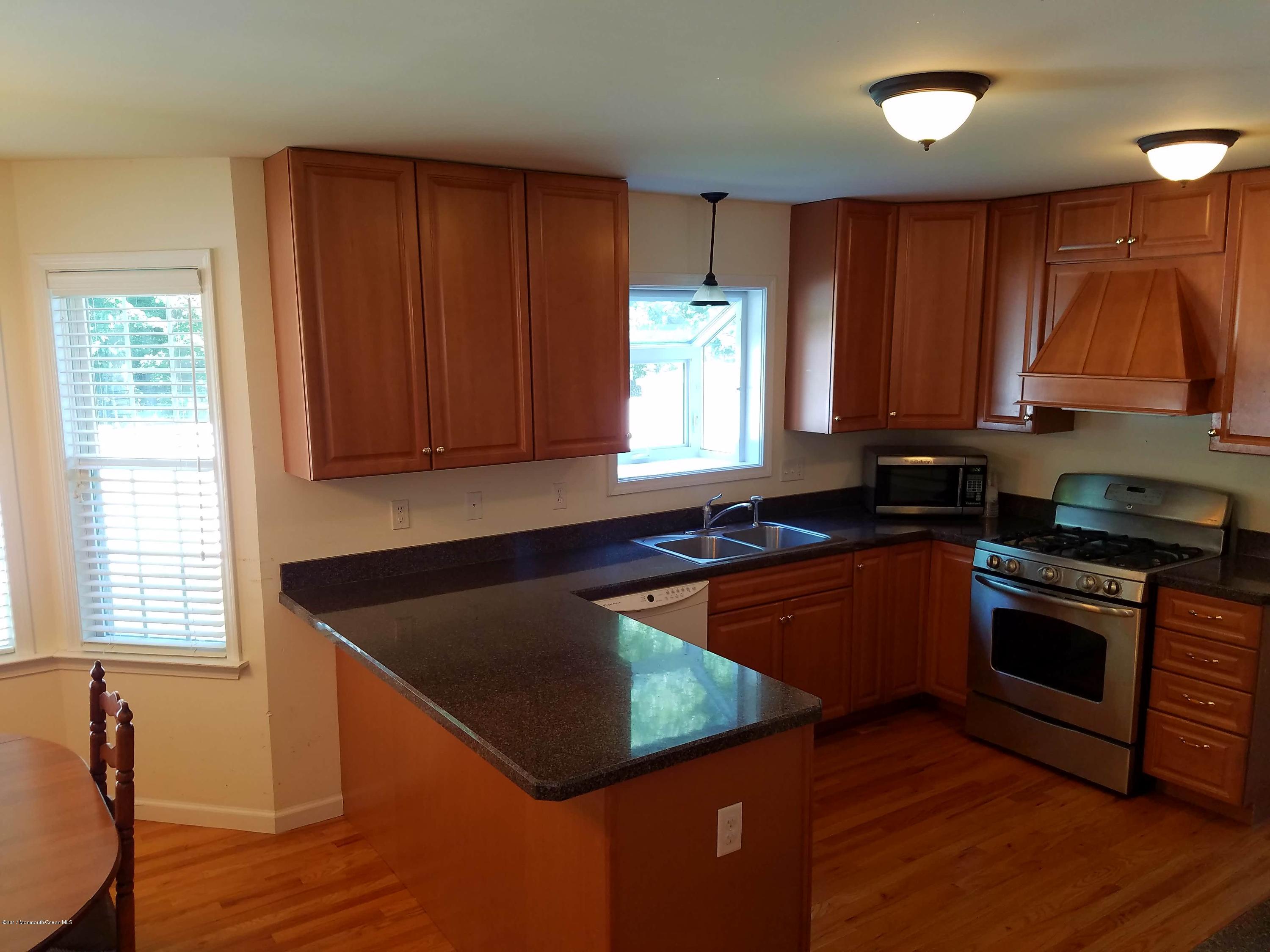 126 Robin Road Neptune Township, NJ 07753 - Photo 6 of 24 a kitchen with stainless steel appliances granite countertop wooden cabinets a stove a sink and a window