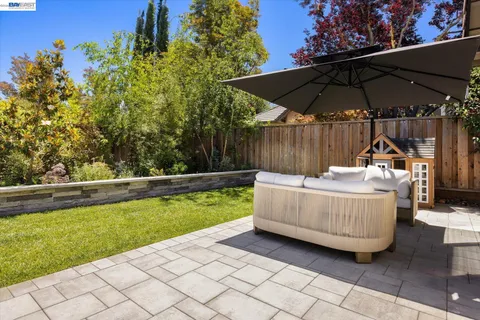 a view of backyard with swimming pool and table under an umbrella