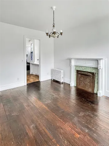 a view of a livingroom with a fireplace a chandelier and stairs