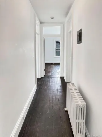 a view of a hallway with wooden floor and entryway
