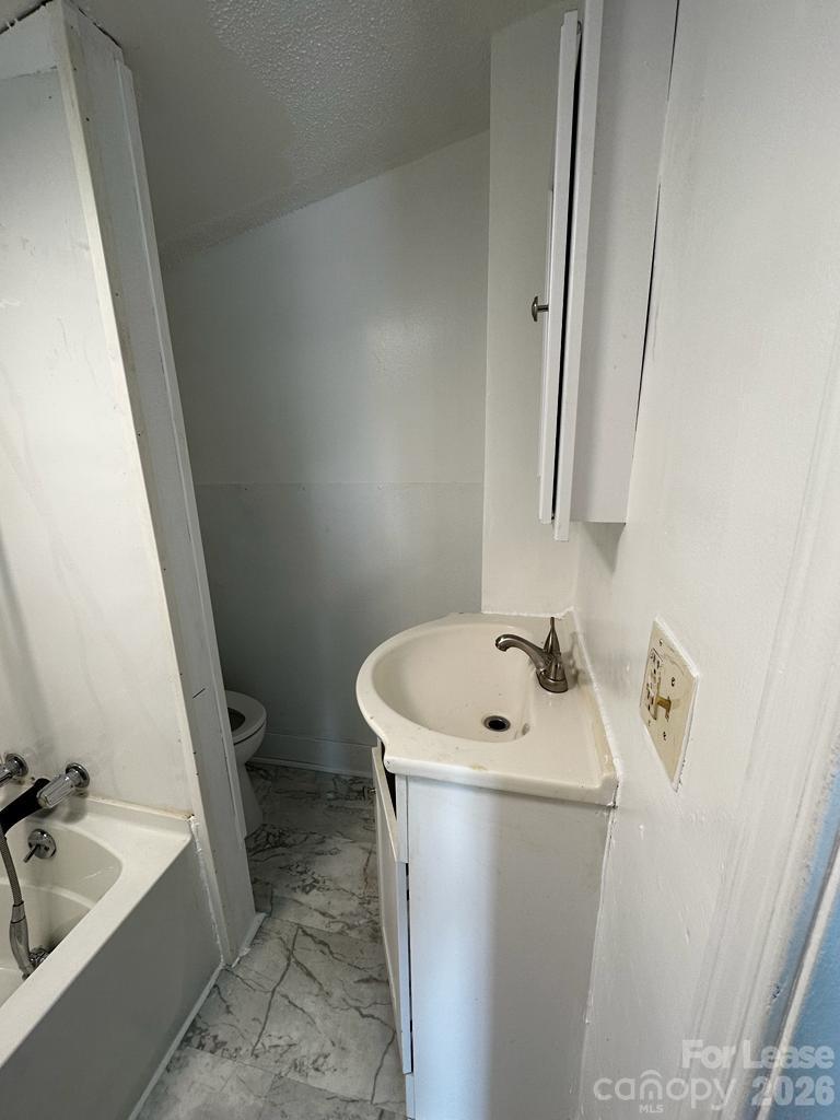 435 Davis Street Albemarle, NC 28001 - Photo 11 of 30 a bathroom with a sink a toilet and bathtub