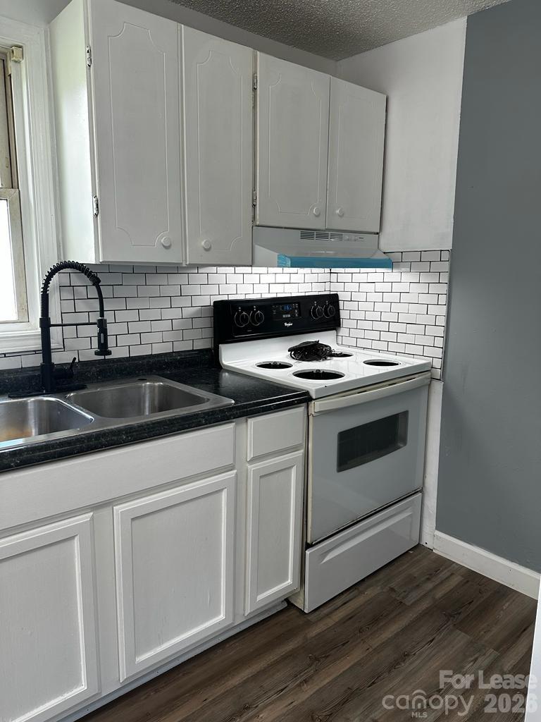 435 Davis Street Albemarle, NC 28001 - Photo 14 of 30 a kitchen with granite countertop white cabinets and white appliances