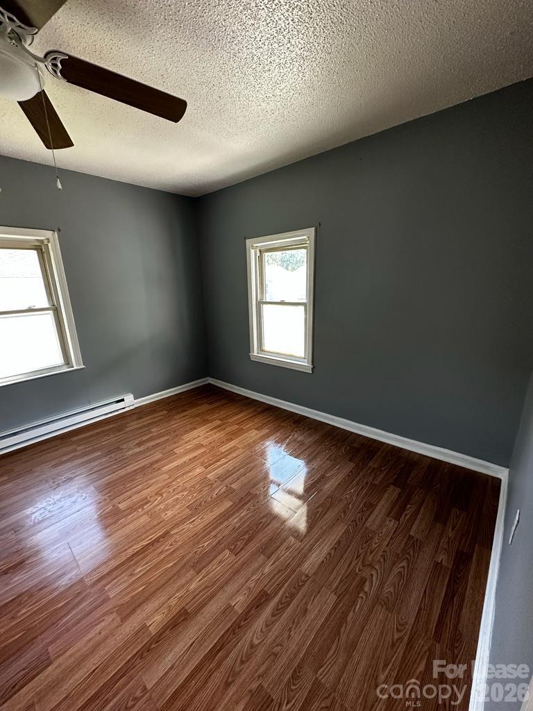 435 Davis Street Albemarle, NC 28001 - Photo 19 of 30 an empty room with wooden floor and windows
