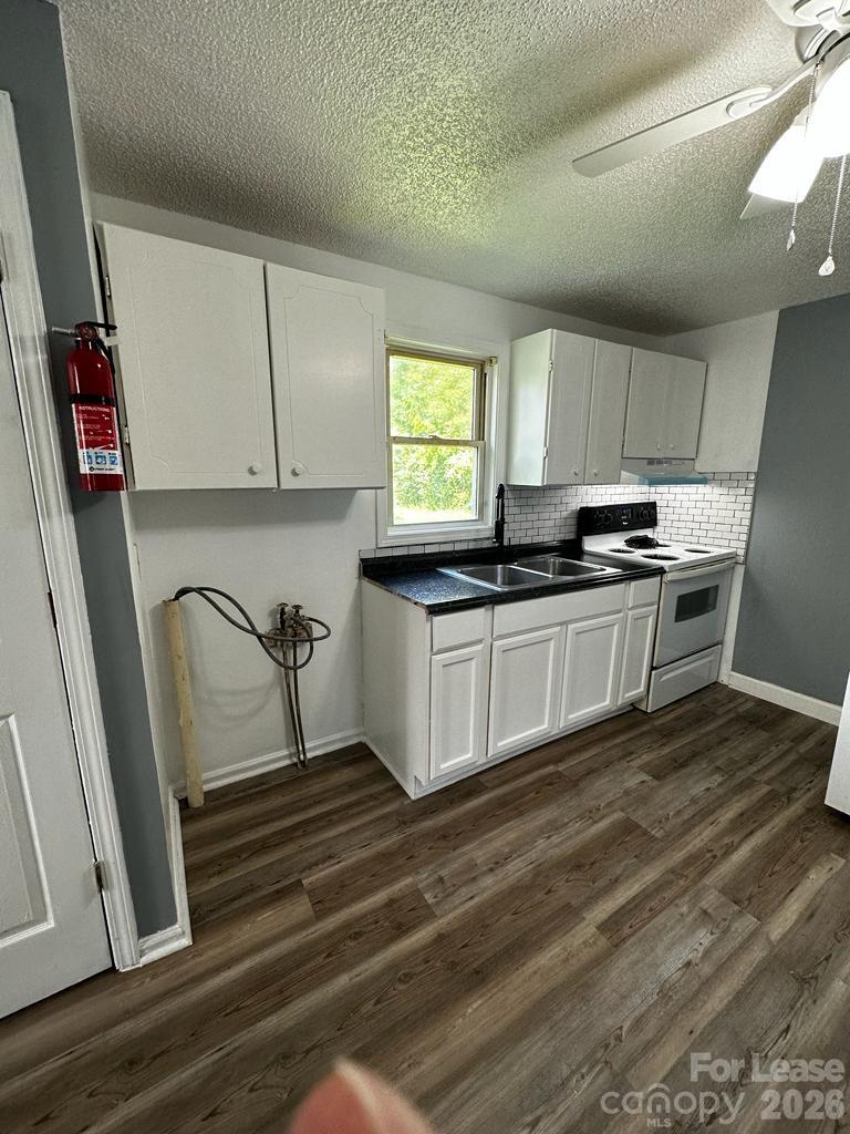 435 Davis Street Albemarle, NC 28001 - Photo 22 of 30 a kitchen with stainless steel appliances granite countertop a sink a stove a refrigerator and cabinets