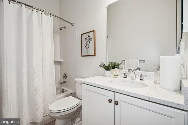 a bathroom with a sink a toilet a mirror a vanity and shower