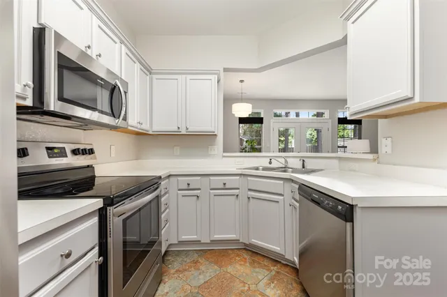 a kitchen with stainless steel appliances granite countertop a sink stove and microwave