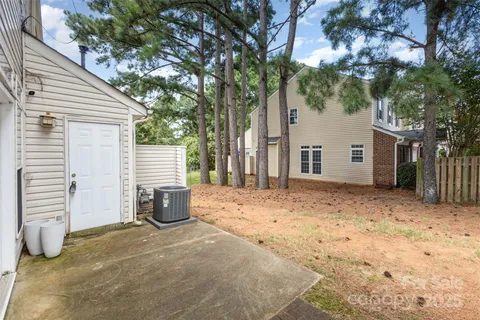 a backyard of a house with barbeque oven and trees