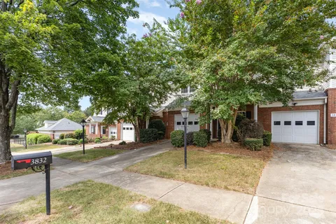 a front view of a house with a yard and tree