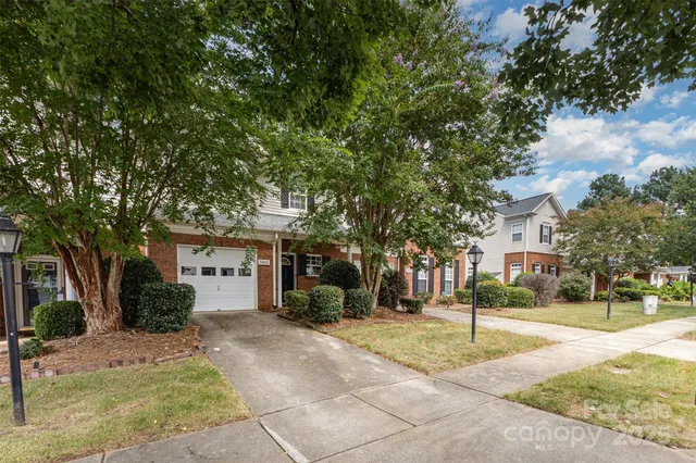 a front view of a house with a yard and trees