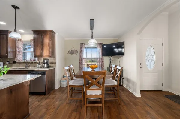 a dining room with furniture a chandelier and wooden floor