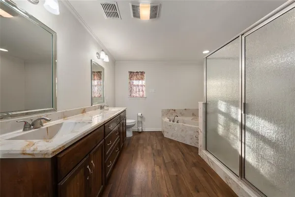 a spacious bathroom with a granite countertop sink a toilet a shower and a mirror