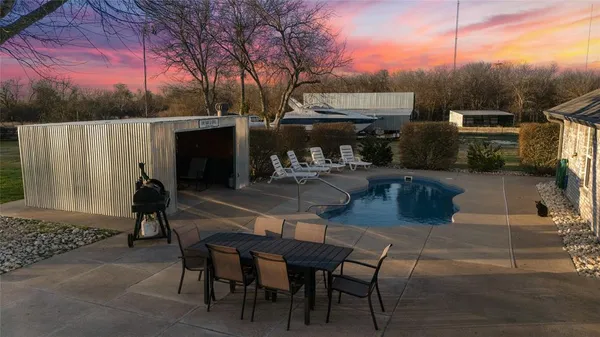 a view of a patio with table and chairs with wooden floor and fence