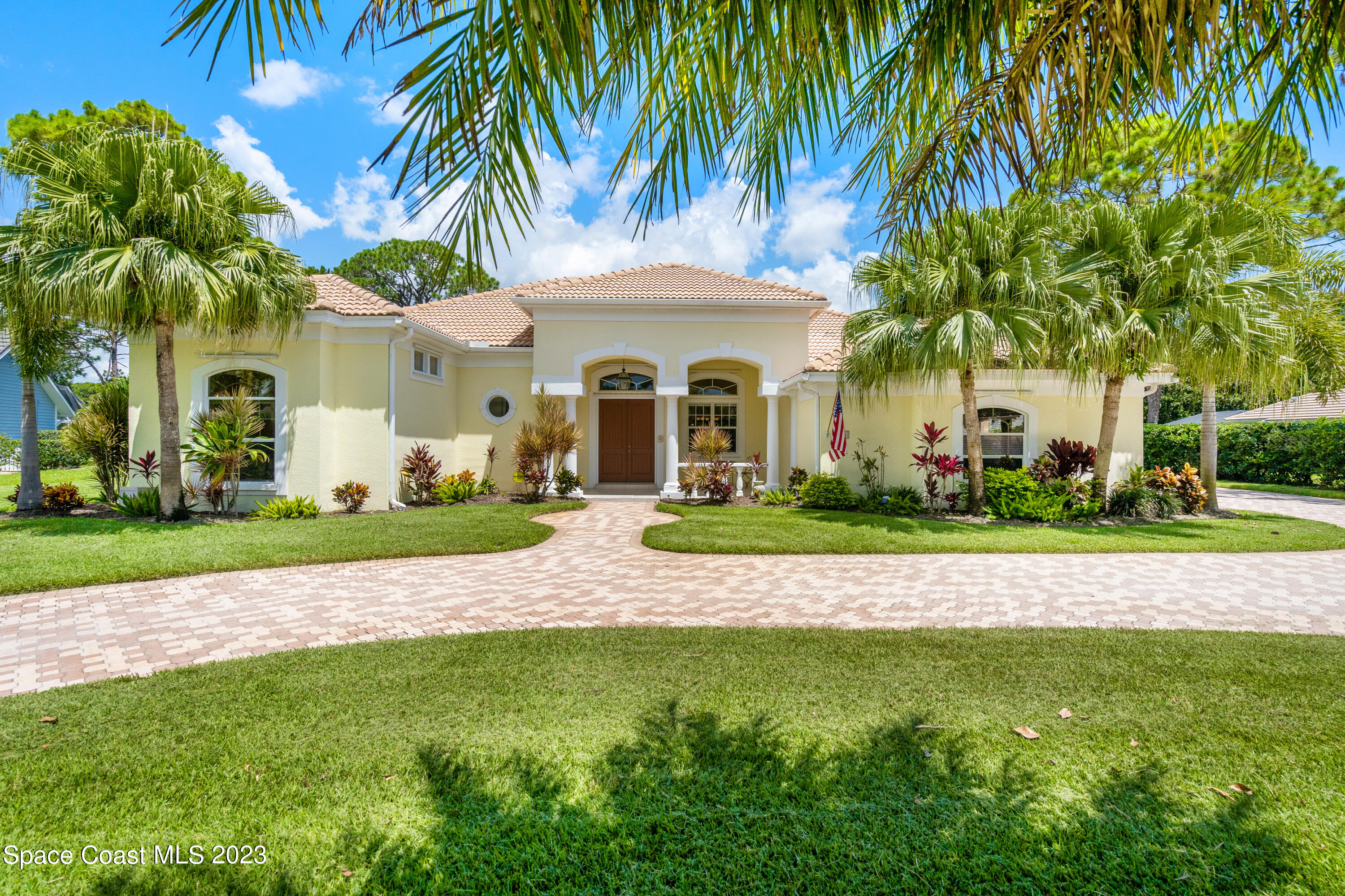 a front view of a house with a garden and trees