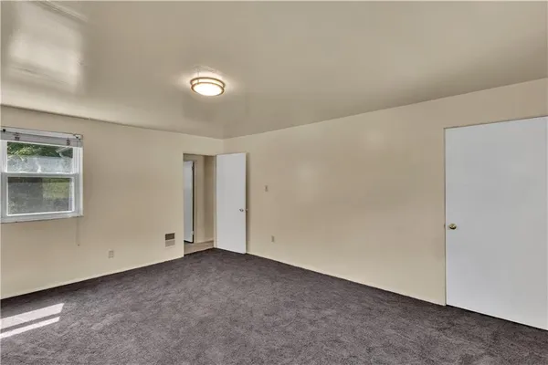 an empty room with a ceiling fan and a window