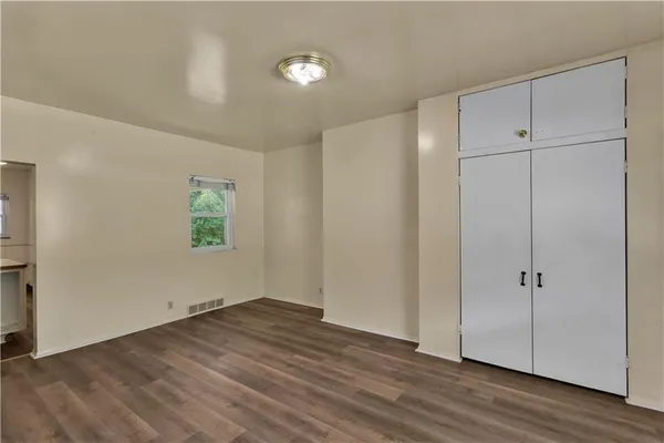 an empty room with wooden floor and closet