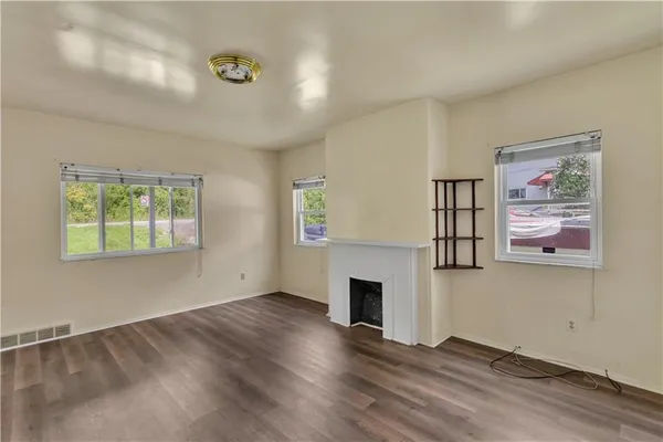 wooden floor fireplace and windows in an empty room