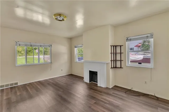 wooden floor fireplace and windows in an empty room