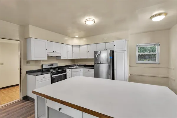 a kitchen with stainless steel appliances granite countertop a refrigerator stove microwave and sink