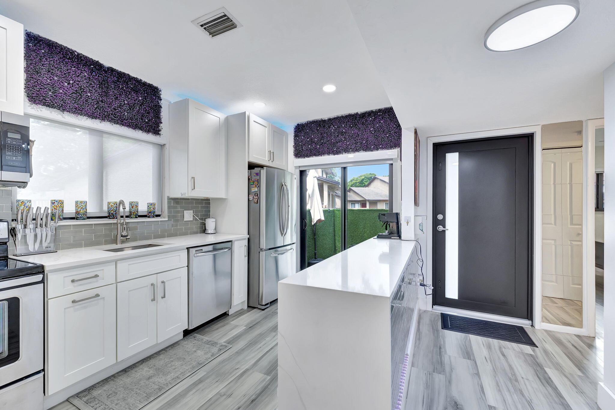 2320 Northwest 37th Avenue, Unit D29 Coconut Creek, FL 33066 - Photo 8 of 27 a open kitchen with white cabinets and wooden floor