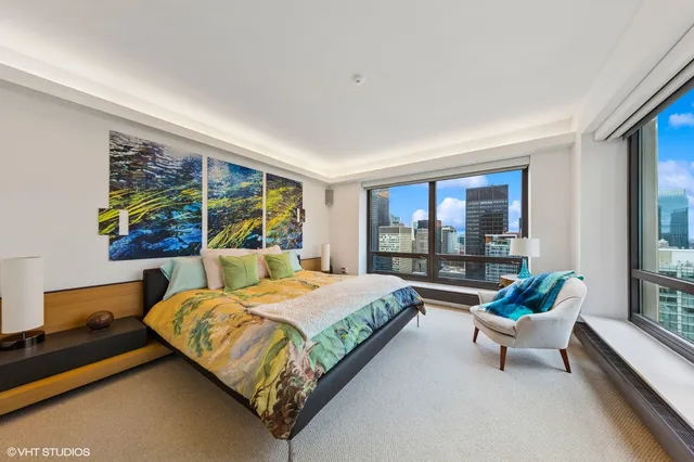 a bedroom with a bed and large windows