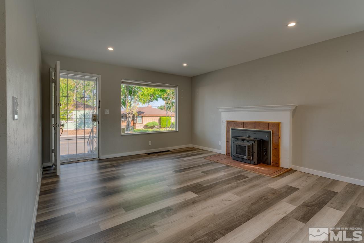 1699 Watt Street Reno, NV 89509 - Photo 7 of 18 a view of empty room with wooden floor and fireplace