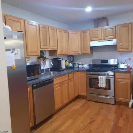 a kitchen with granite countertop a stove top oven sink and cabinets