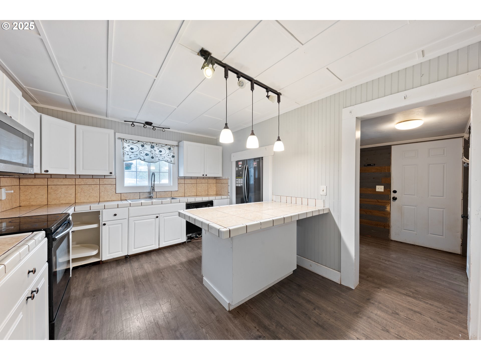 31778 Highway 213 Molalla, OR 97038 - Photo 13 of 47 a view of a kitchen with kitchen island a sink wooden floor and stainless steel appliances