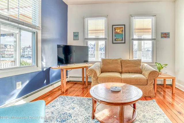 a living room with furniture a flat screen tv and a large window