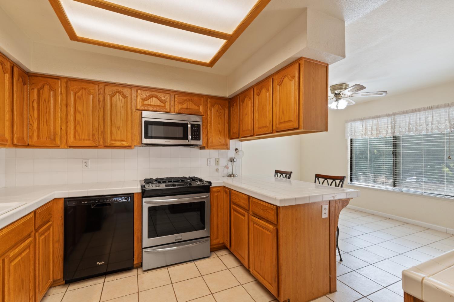 40809 Jean Road West Oakhurst, CA 93644 - Photo 17 of 39 a kitchen with granite countertop a stove top oven microwave and cabinets