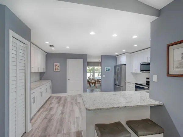 a view of kitchen island wooden floor center island and stainless steel appliances