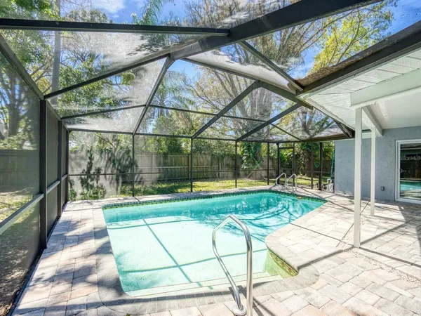 a view of backyard with a table and chairs and a large tree