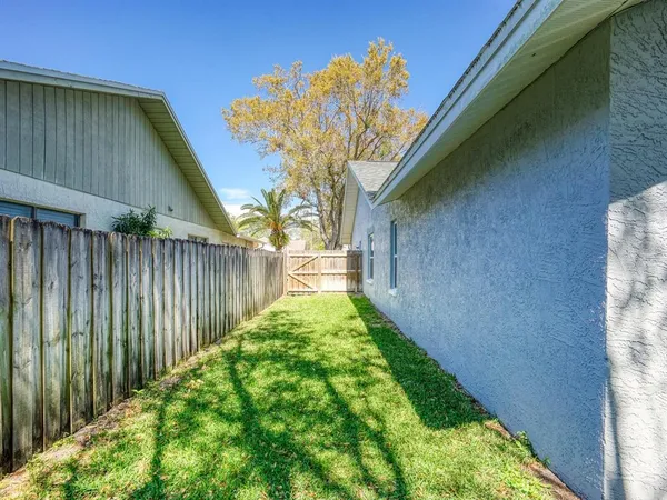 a view of a house with backyard and a tree