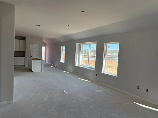a view of an empty room with a window and fireplace