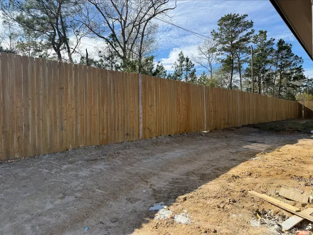 a view of backyard with wooden fence