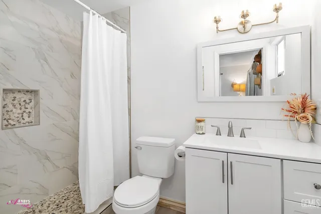a bathroom with a sink vanity mirror and toilet