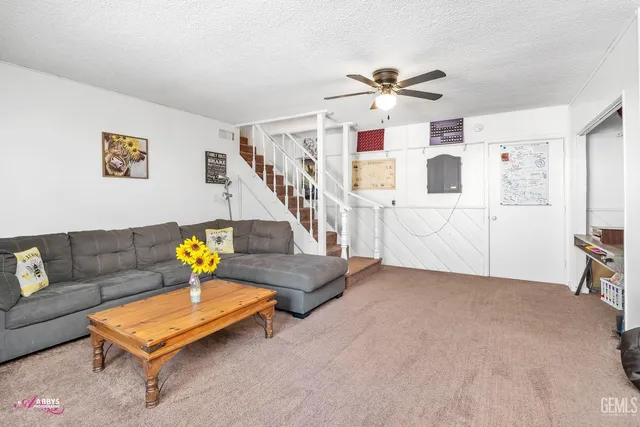 a living room with furniture and stairs