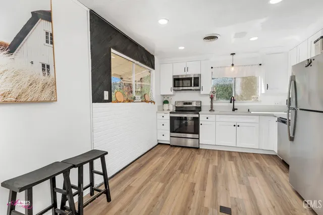 a kitchen with stainless steel appliances a refrigerator sink and microwave