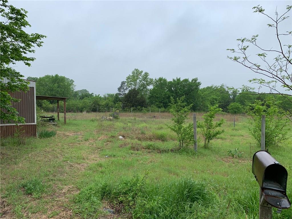 a view of a green field with wooden fence