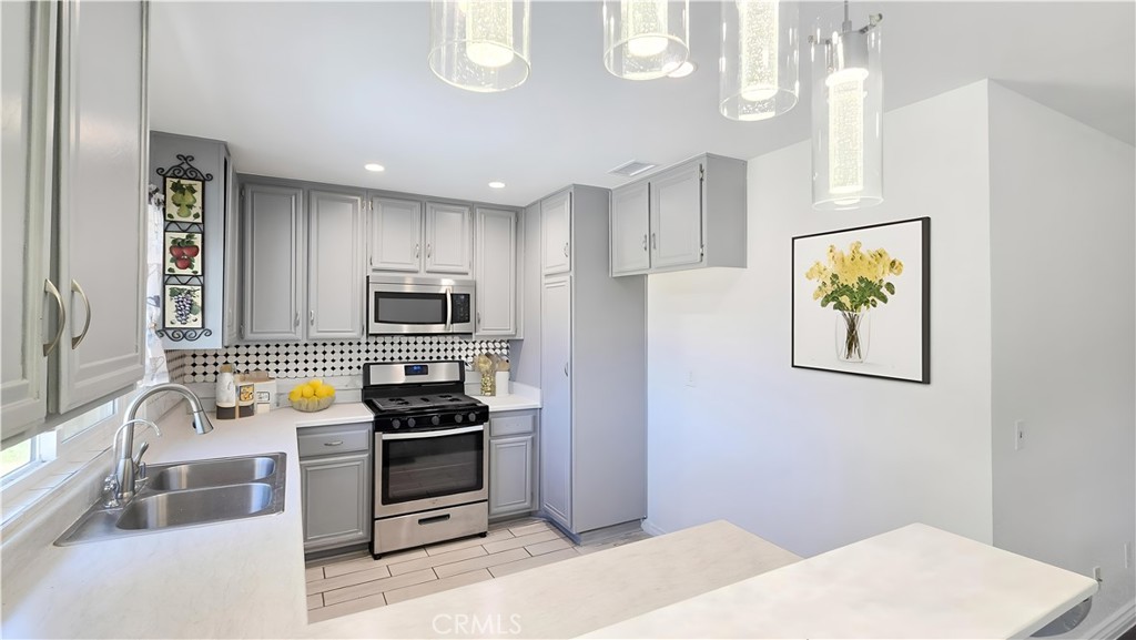 1025 Lightcap Street Lancaster, CA 93535 - Photo 2 of 13 a kitchen with a refrigerator and a stove top oven