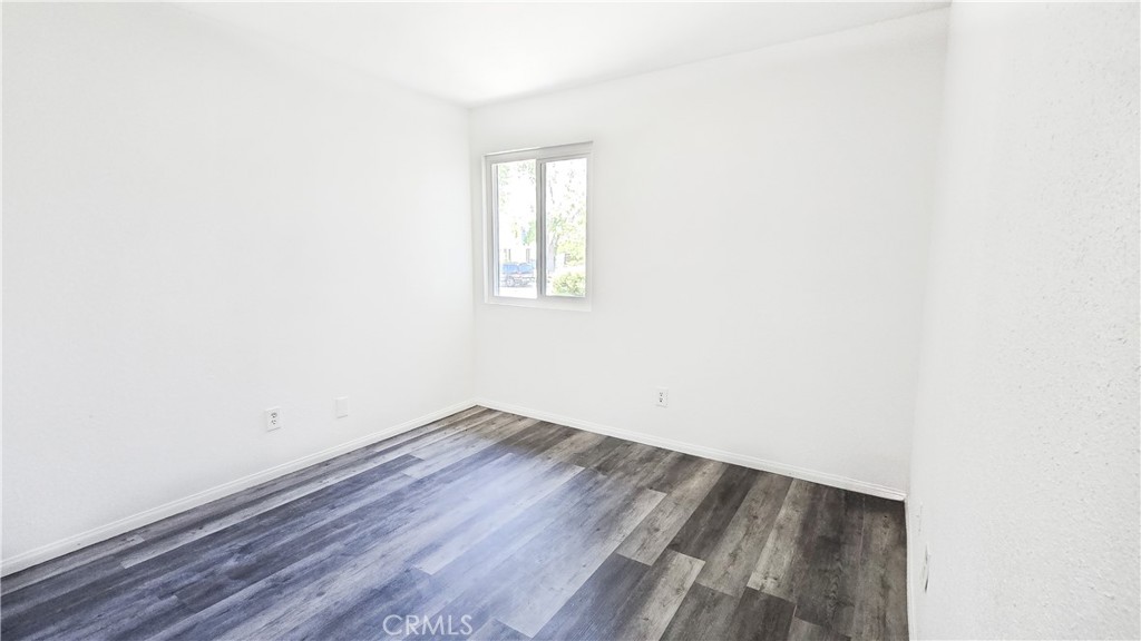 1025 Lightcap Street Lancaster, CA 93535 - Photo 3 of 13 a view of an empty room with wooden floor and a window