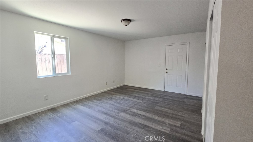 1025 Lightcap Street Lancaster, CA 93535 - Photo 4 of 13 a view of an empty room with wooden floor and a window