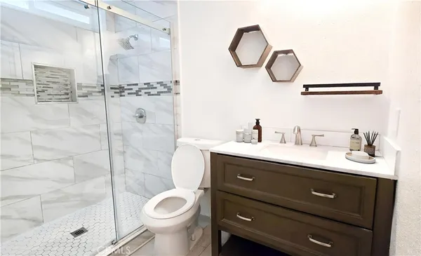 a bathroom with a granite countertop sink mirror and toilet